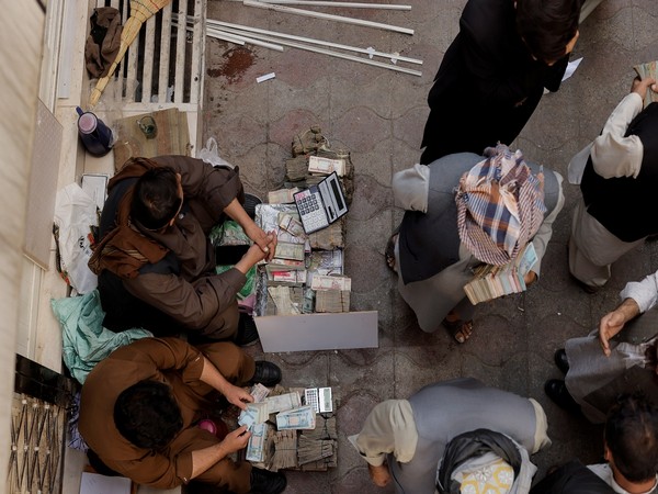 People exchange money at a currency exchange market in Kabul. (Photo Credit - Reuters)