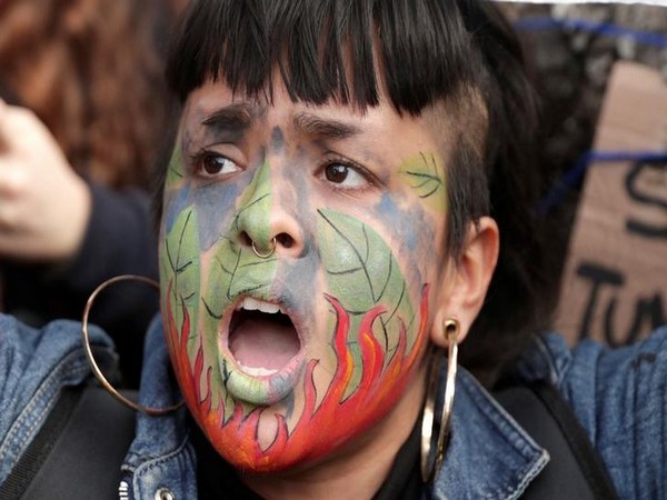 A demonstrator shouts slogans during a protest outside the Brazilian embassy due to the wildfires in the Amazon rainforest, in Lima, Peru