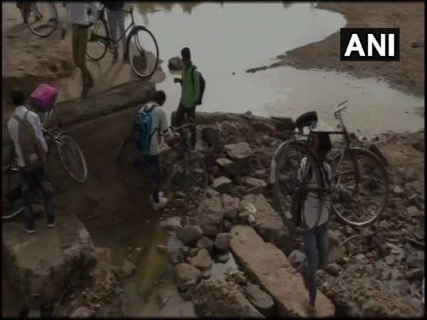 Children crossing the river to reach their school through broken bridge in Umaria 