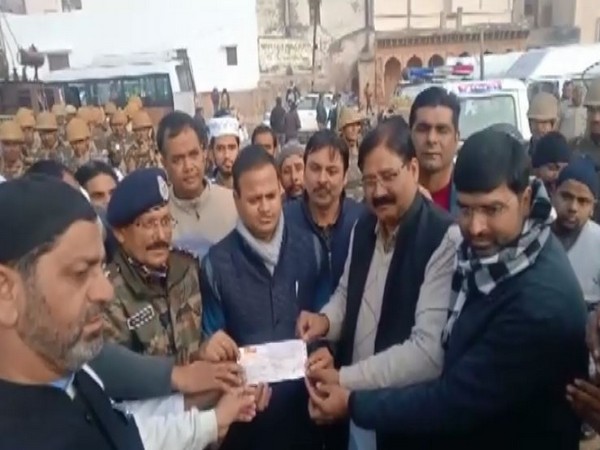 Members of the Muslim community handing over cheque to administration officials in Bulandshahr on Friday. photo/ANI