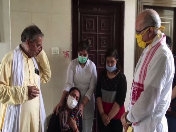 Uttar Pradesh Minister of State (PWD), Chandrika Prasad Upadhyay with family memebers of slain DSP Devendra Mishra in Kanpur on Tuesday. (Photo/ANI)
