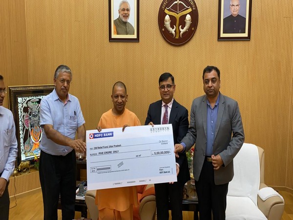 HDFC Bank officials present a cheque of Rs 5 crore to Chief Minister Yogi Adityanath at his residence here. Photo/ANI