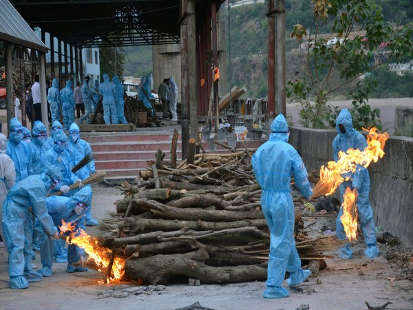 People in PPE kit perform last rites of a COVID-19 victim at Jogi gate in Jammu on May 7. (Photo/ANI)