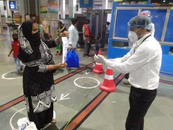 A ticket-checker checks the ticket of a passenger with the CheckIn Master App. (Photo/ANI)