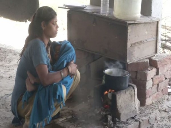 A labourer cooking food at a construction site in Greater Noida on Friday. Photo/ANI
