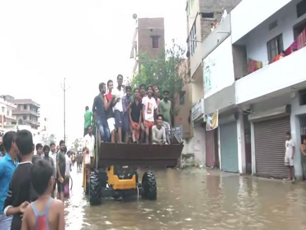 Residents in Patna are forced to commute via Patna Municipality Corporation's JCB. (Photo/ANI)