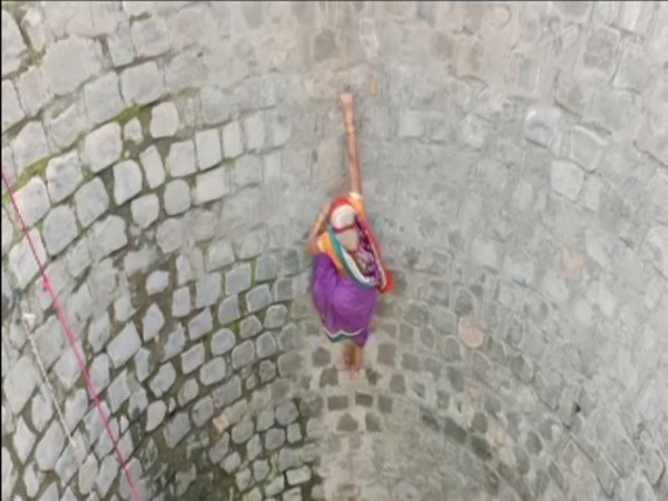 Woman climbing up in a well in Ghusiya panchayat in Madhya Pradesh's  Dindori