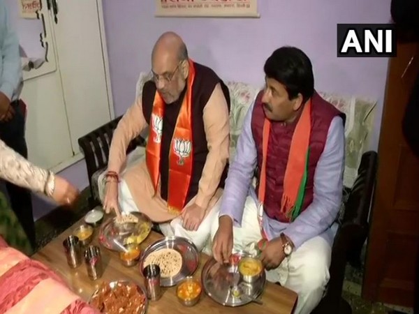 Union Home Minister Amit Shah and Delhi BJP Chief Manoj Tiwari having dinner at BJP worker's residence in Yamuna Vihar on Friday (Photo/ANI)