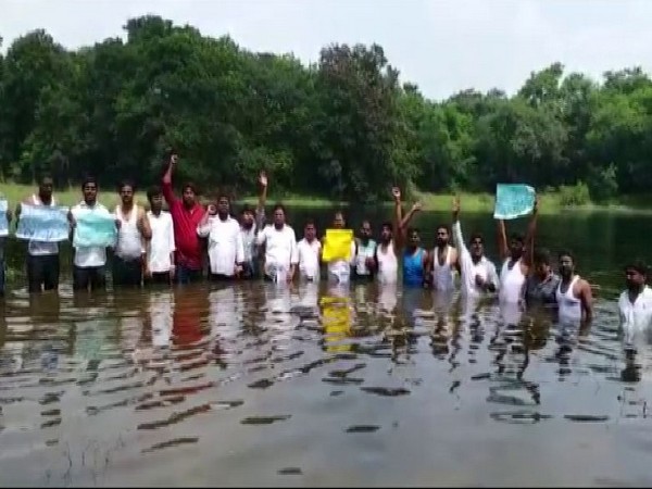 Osmania University JAC member-students staged a protest by standing in water in the university premises on Tuesday. Photo/ANI