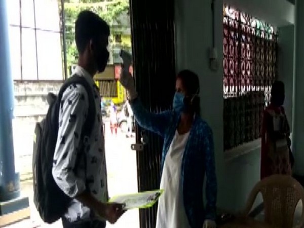 An examinee being checked for his body temperature at a CET centre, Shivamogga. (Photo/ANI)