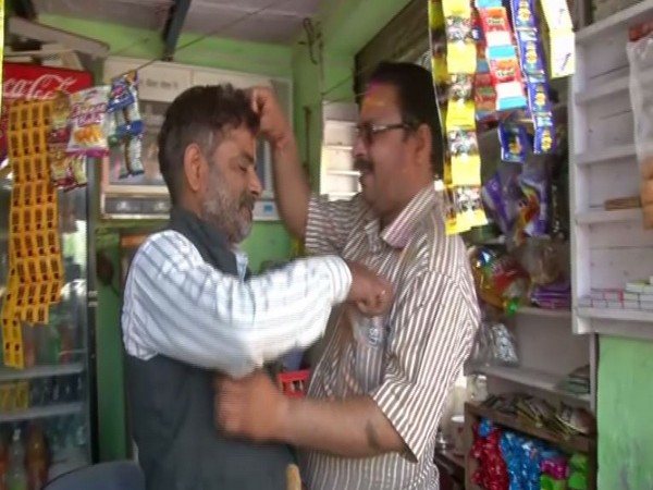 Vipin Gupta and Zahid Hussain smear each other with gulal on Holi, in Delhi's Yamuna Vihar on Tuesday. Photo/ANI