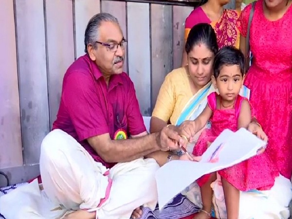  Children introduced to reading and writing on  Vidyarambham ceremony in Kerala on Tuesday. Photo/ANI