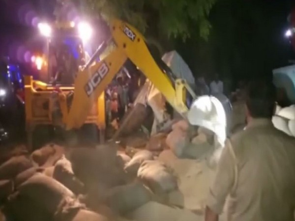 A truck carrying wheat sacks overturned in Badaun district's Alapur area on Monday. Photo/ANI
