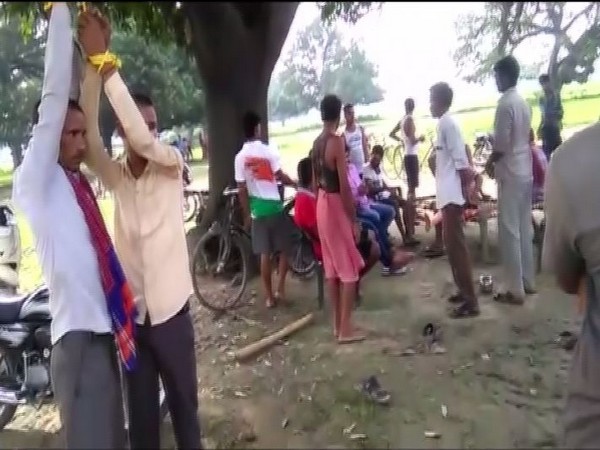 Pawan Gaunda (L) with his father were tied to a tree in Prayagraj on Friday. [Photo/ANI]