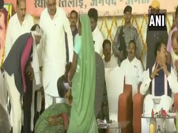 A woman on Saturday fell at the feet of Union Minister Smriti Irani during her visit to Amethi, seeking help in land grabbing case. Photo/ANI