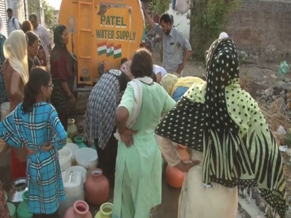 Residents of Mehboob Nagar standing in a queue to fetch water from a water tank. Photo/ANI