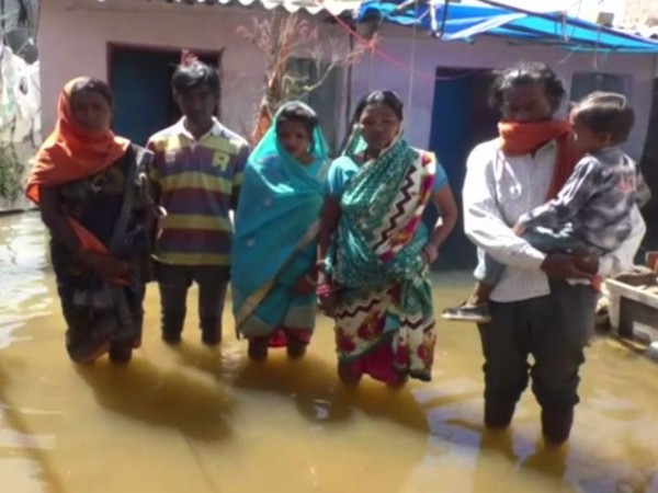 Family members standing outside their flooded house (Photo/ANI)