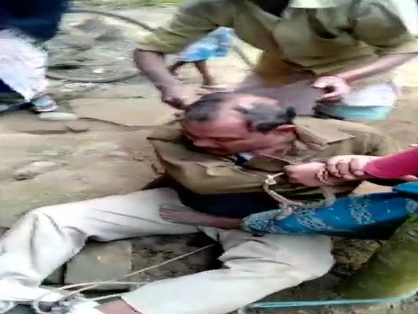 A police officer being tonsured by the mob in Assam's Nagaon (Photo/ANI)