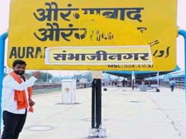 Unidentified miscreant posing with the board at the Aurangabad railway station. Photo/ANI