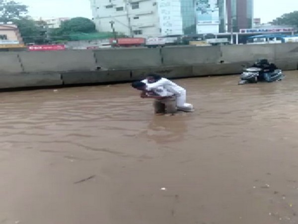 A traffic inspector, A Nagamallu carried a sick person on his shoulders, across a waterlogged route in Hyderabad on Saturday. (Photo/ANI)