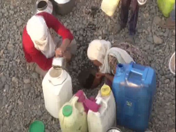 Women pulling water from a small pit in Kawatha village. [Photo/ANI]
