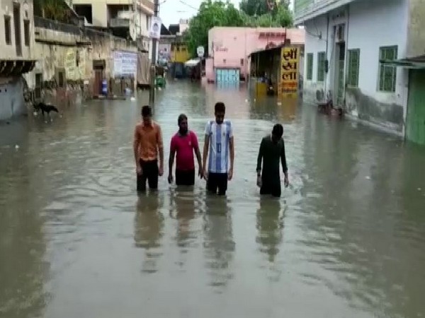 Locals forced them to wade through knee-deep waters triggered by heavy downpour in Churu, Rajasthan (Photo/ANI)