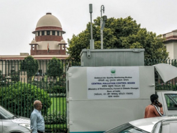 People walking past an Ambient Air Quality Monitoring Station at the Supreme Court in New Delhi (File photo)