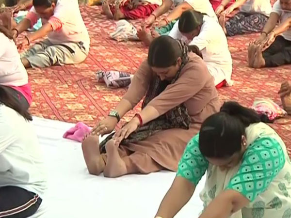 Union Minister Smriti Irani in brown kurta performing a yoga asana in Dwarka, New Delhi [Photo/ANI]
