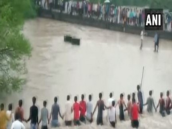 Locals formed a long human chain to rescue two people who were washed away in an overflowing stream in Indore’s Gautampura. (Photo/ANI)