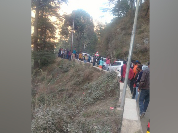 People gathered at the spot where a car fell into a gorge at Dobata area of Barkot town on Saturday.