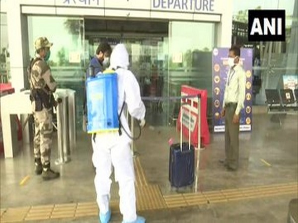 Airport staff disinfects luggage of passengers arriving at Swami Vivekananda Airport in Raipur on Monday. [Photo/ANI]