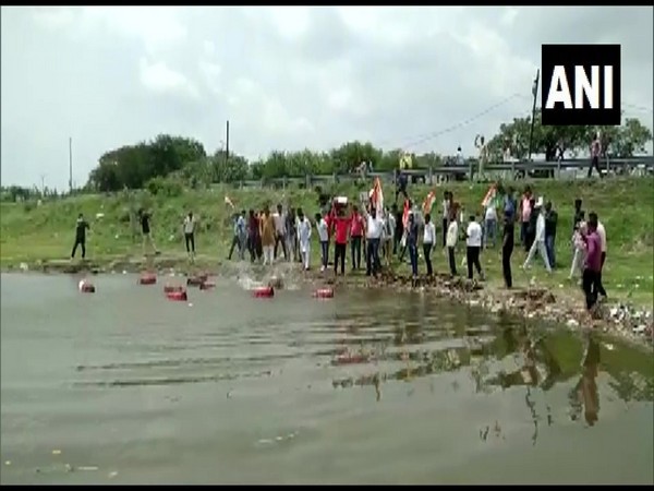Congress workers throwing gas cylinders in Dewas' Meetha Taalab. (Photo/ANI)