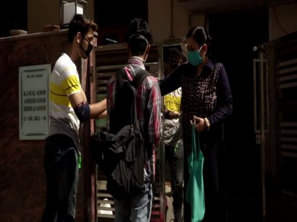 Vaibhav and Sarthak delivering essentials to society members. Photo/ANI