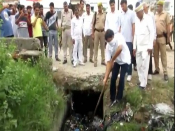District Magistrate Aunjaneya Kumar Singh seen cleaning drains in Rampur on Saturday. Photo/ANI