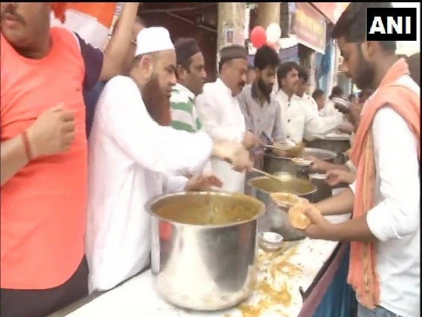 Members of the Aman Committee distributing food to people participating in the Shobha Yatra in Delhi's Hauz Qazi area on Tuesday. Photo/ANI   