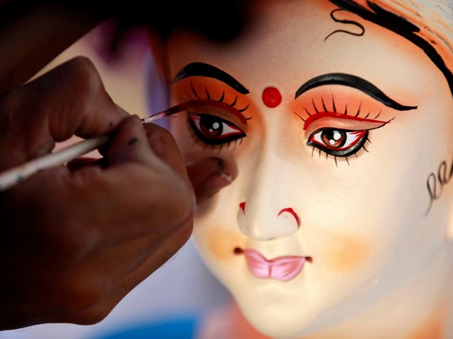 A man gives a finishing touch to an idol of Goddess Durga before selling it to a customer ahead of Dashain festival. (Photo Credit - Reuters)