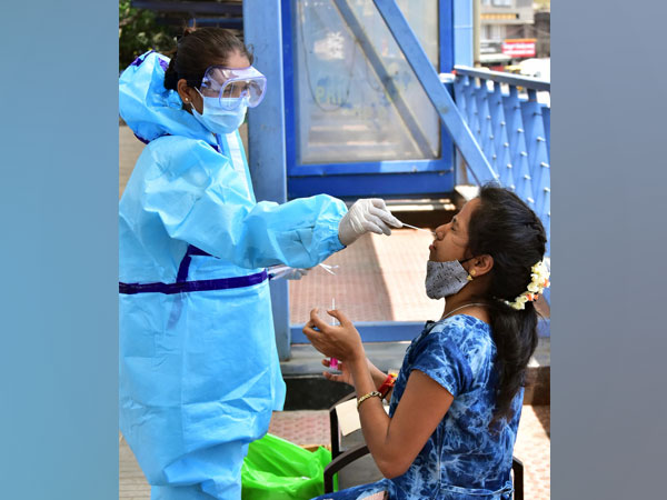 A medic wearing a PPE kit collects a swab sample for the COVID-19 test amid the rise in cases, (Photo/ANI)