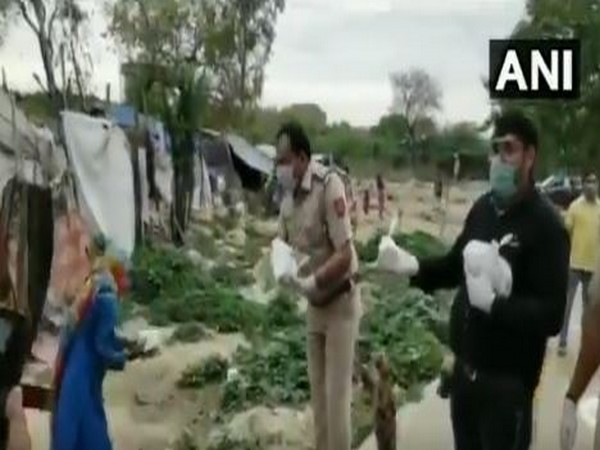 Delhi Police officials distributing food packets to the needy in Najafgarh area on Thursday.