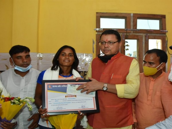 Pushkar Singh Dhami felicitating hockey player Vandana Katariya. (Photo/ANI)