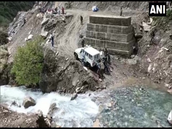 Locals helping a car to get back on the road in Dharchula, Uttarakhand on Friday. (Photo/ANI)