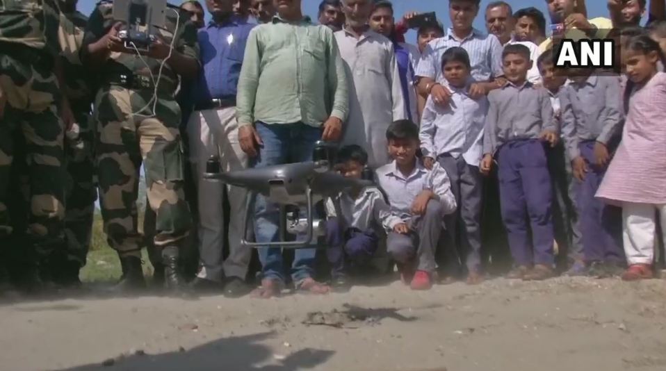 Children watch in awe as BSF demonstrates application of a drone to the locals in Jammu. Photo/ANI