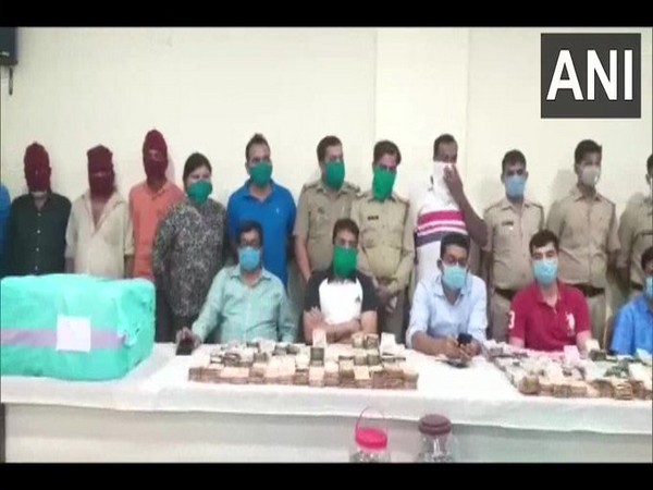 The police team with the arrested accused, and the drugs and cash recovered in the bust. Photo/ANI