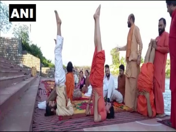 Saints perform Yoga on the banks of river Ganga in Haridwar. (Photo/ANI)