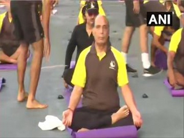 Defence Minister Rajnath Singh performing yoga onboard INS Vikramaditya on Sunday morning. (Photo/ANI)