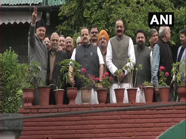 Farooq, clad in a grey suit, looked hale and hearty. He made a peace sign as he stood with the visiting party leaders for a photograph. (Photo/ANI)