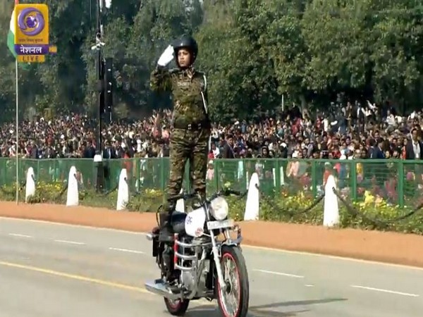 Inspector Seema Nag, salutes standing on top of a moving motorcycle
