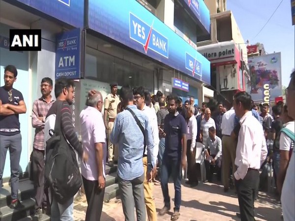 People gathered outside Yes Bank's branch on Chimanlal Girdharlal Road in Ahmadabad. [Photo/ANI]