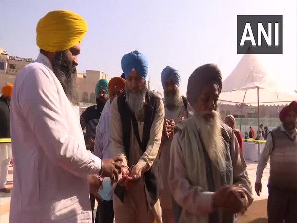 SGCP members handing out sanitisers to devotees at the entry gate of Golden Temple, Amritsar on Wednesday. Photo/ANI