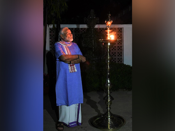 PM Narendra Modi lights a lamp after turning off all lights at his residence.