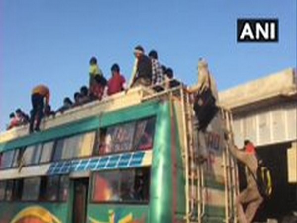 Migrant workers take buses from Ghaziabad's Lal Kuan to their respective hometowns after walking on foot from Delhi, Gurugram and other places. Photo/ANI